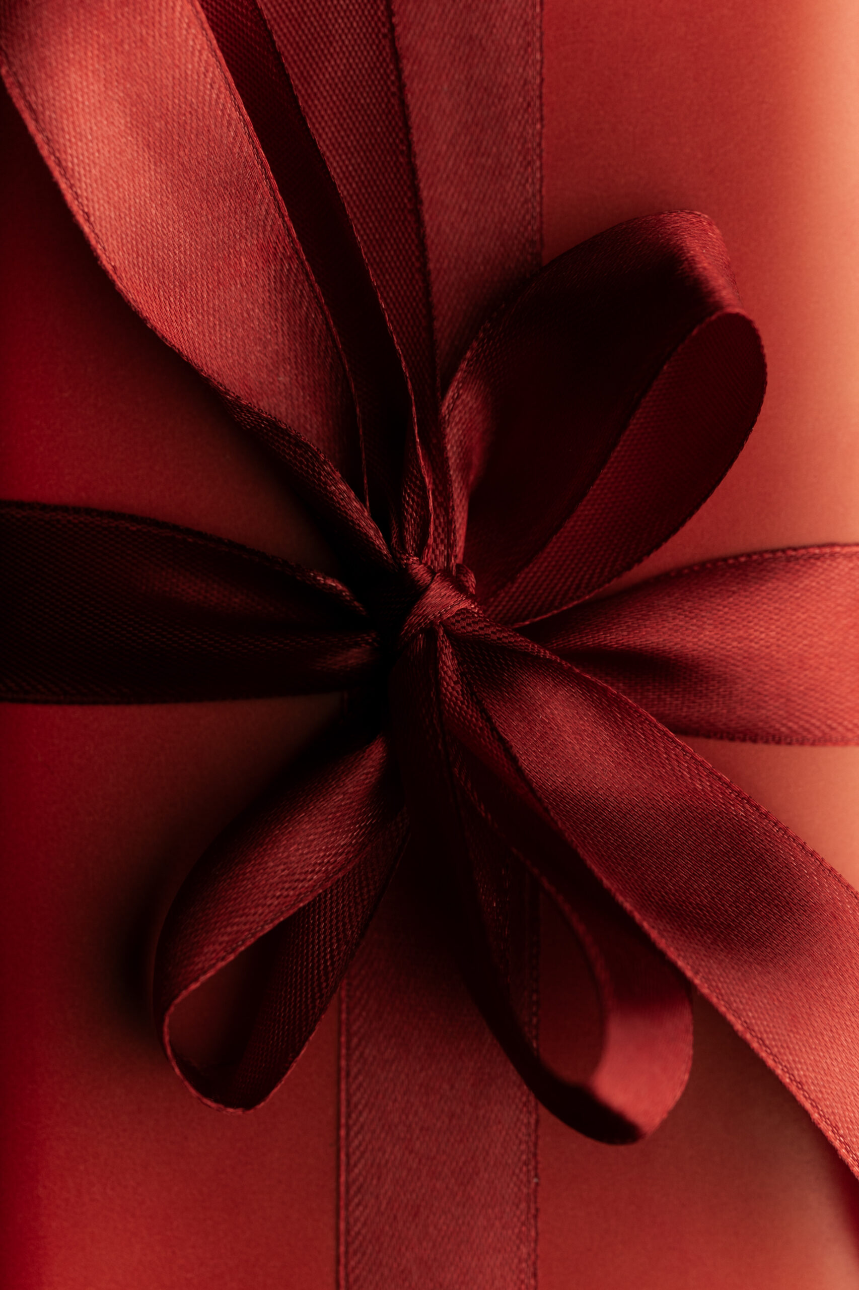 Czerwony prezent z czerwoną wstążką zawiązaną w kokartkę